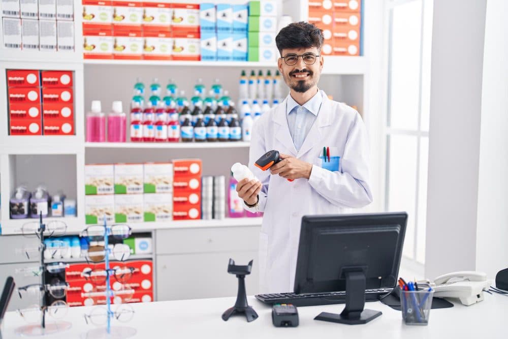 Pharmacist scanning a medicine bottle at a pharmacy counter