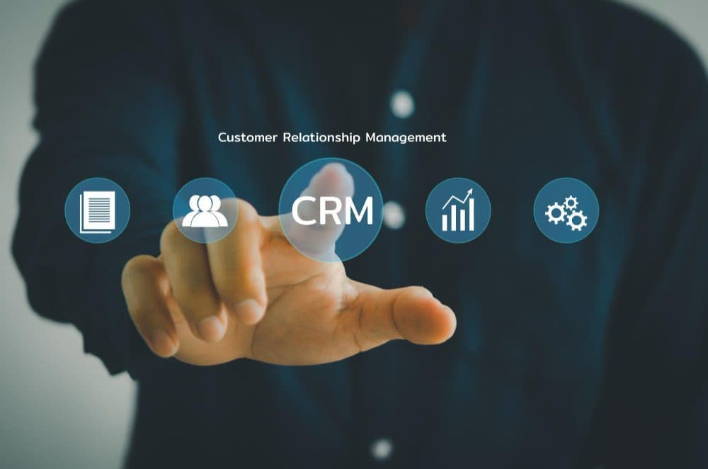 Hand touching a CRM interface on a virtual screen